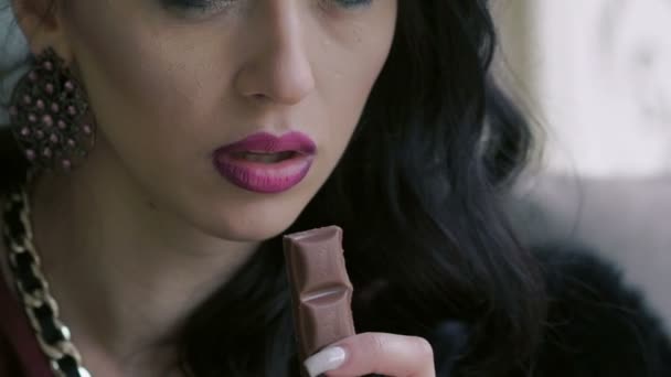 Primer plano de la boca de las mujeres mordiendo un pedazo de chocolate negro. Despacio. — Vídeos de Stock