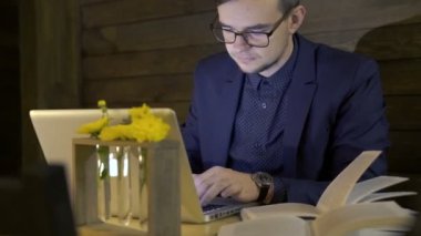 İşadamı için laptop bir kafede bir masada bir kitaptan bilgileri yeniden yazma