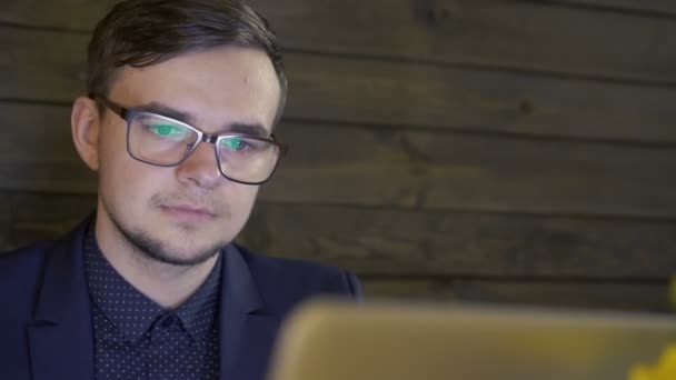 Podnikatel hledá na přenosném počítači a diskutovat v kavárně — Stock video