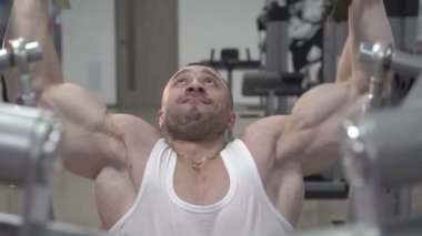 Spor salonunda egzersiz yapan çok güçlü erkek. Yavaş yavaş