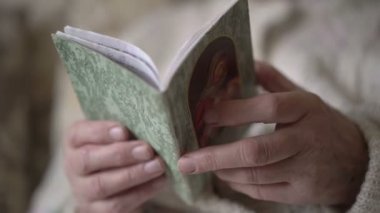Yaşlı kadının elinde dua kitabı. Yavaş yavaş