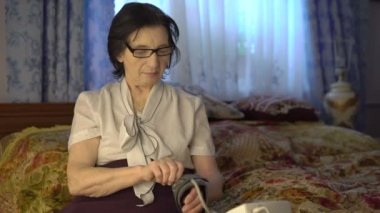 Tansiyon ölçme aracı yandan koyarak eski hoş kadın.