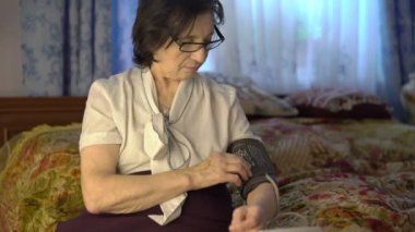 yorgun kadın tansiyon ölçme aracı üzerinde elini koydu..