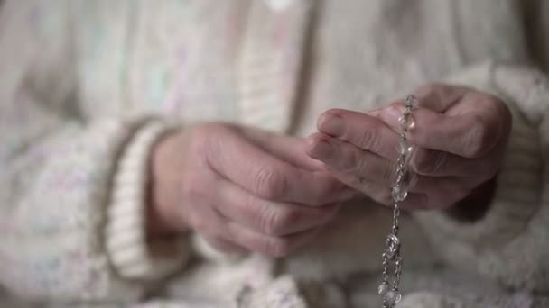 Mãos femininas rezando com rosário de cristal — Vídeo de Stock