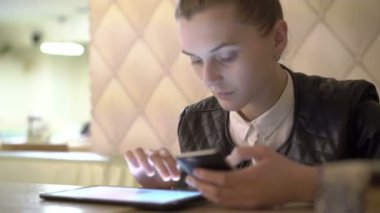 Kızın tablet ve telefon kafede kullanarak kapatın. 4k