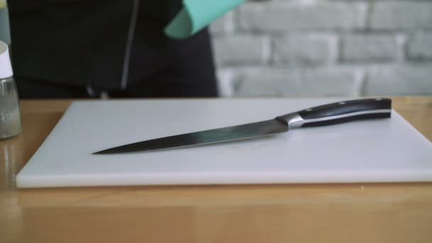 Primer plano de vídeo de cuchillo de cocina, tabla en la mesa. El hombre que se lo lleva 4k — Vídeos de Stock