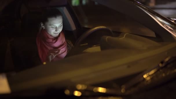 Vista de la chica a través del parabrisas del coche negro por la noche, lloviendo. 4K — Vídeos de Stock