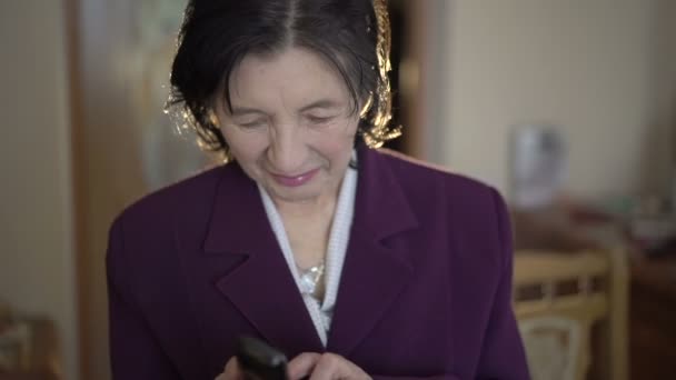 Stará žena vytáčení čísla, mluvit do telefonu, s úsměvem — Stock video