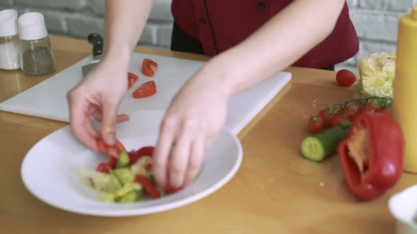 Женщина нарезает помидоры для овощного салата, готовится на кухне ресторана 4k — стоковое видео