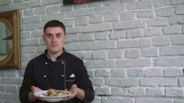 Şef Aşçı siyah üniformalı tat salata beyaz tuğla duvar arka planda 4 k sunar