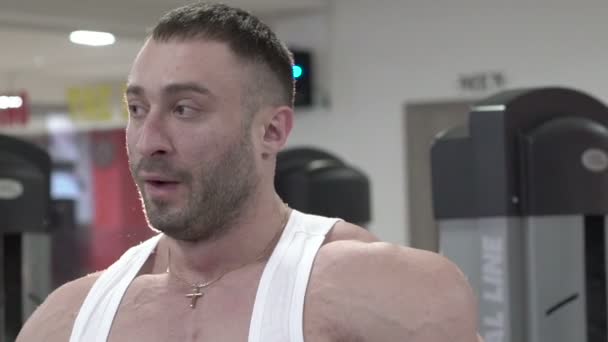 Bello bodybuilder muscolare in posa su sfondo nero. Lentamente. — Video Stock