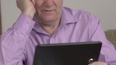 Yaşlı adam tablet kullanır. Yakın çekim