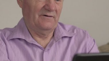 Yaşlı adam tablet kullanır, gülümse. Yavaş yavaş