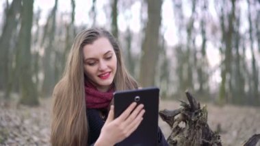 Ormanda, 4 k bir tablet kullanan bir kızın yakın çekim yüz