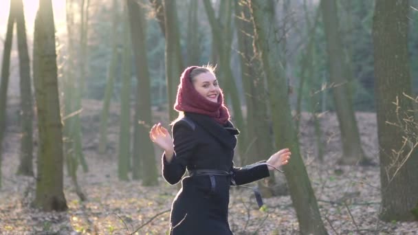 सुंदर लड़की एक धूप वसंत जंगल में कूद रही है। धीरे-धीरे — स्टॉक वीडियो