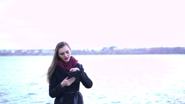 Junge schöne Frau mit Tablette in der Nähe des Sees — Stockvideo