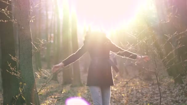 Ugrás egy napsütéses tavaszi erdő gyönyörű lány. Lassan — Stock videók