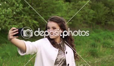 Pretty genç kız bahçede selfie için poz. Yavaş yavaş