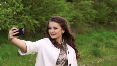 Pretty genç kız bahçede selfie için poz. Yavaş yavaş