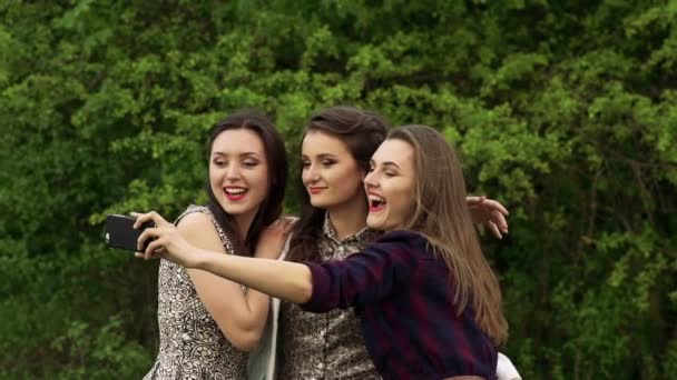 Tres chicas posando para selfie cerca de árboles verdes. Despacio. — Vídeos de Stock