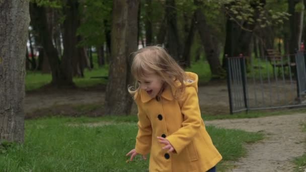 Enfant souriant courant sur l'herbe. Doucement. 