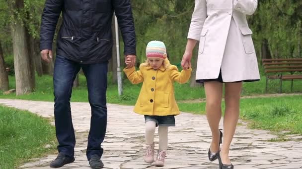 Счастливая семья с маленькой девочкой, гуляющей в парке. Медленно. — стоковое видео