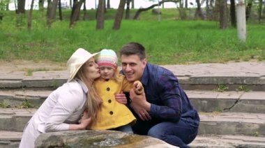 Çeşme bir parkta yakınındaki dinlenme kızı ile mutlu bir aile. Yavaş yavaş