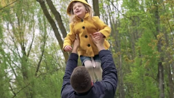 Pai brincando com filha menina trowing no ar em um parque. Devagar. — Vídeo de Stock