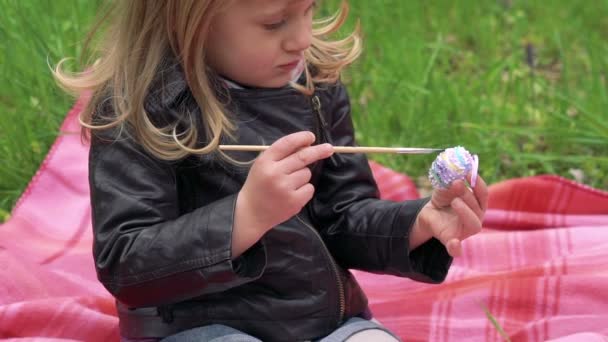 Close up de bebê menina pintando ovo decorativo para a Páscoa. Devagar. — Vídeo de Stock