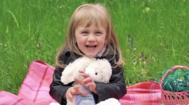 Yumuşak oyuncak bir kameraya gülümseyen küçük kız. Yavaş yavaş