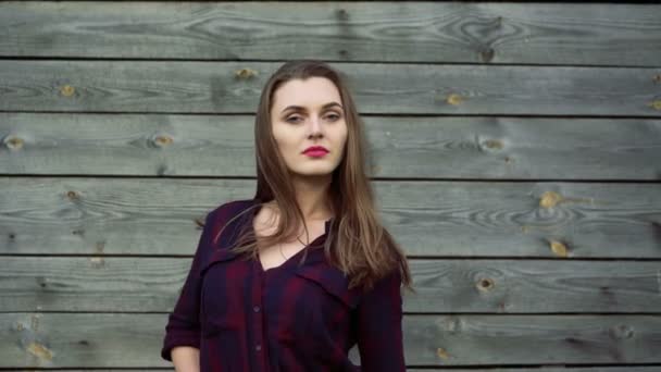 Krásná dívka pózuje na šedém pozadí dřevěná. 4k — Stock video
