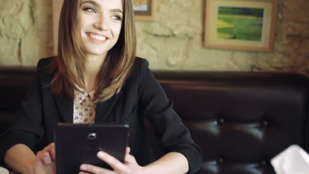 Feliz chica de negocios usando en la tableta, beber café y mirando en la ventana 4k — Vídeos de Stock