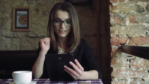 Señora de negocios que trabaja con una tableta y sorprendente en la cafetería moderna 4k — Vídeos de Stock