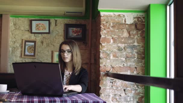 风格女人在现代咖啡厅 4 k 表使用一台笔记本电脑 — 图库视频影像