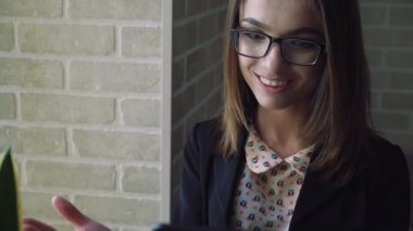 Tablet yakın pencere ve merak arayan genç kadın. 4k