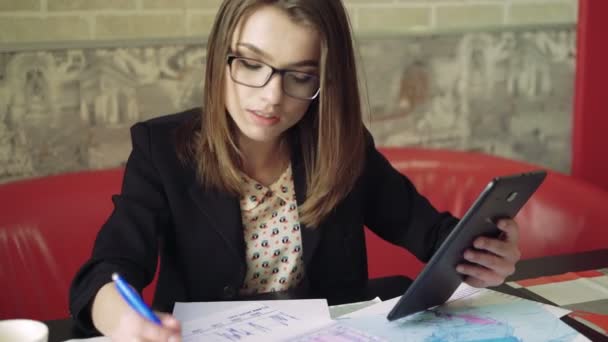 Ділова жінка, що працює з документами та планшетом у кафе 4k — стокове відео