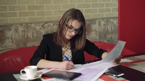 Chica de negocios que trabaja con la tableta y documentos en la cafetería 4k — Vídeos de Stock