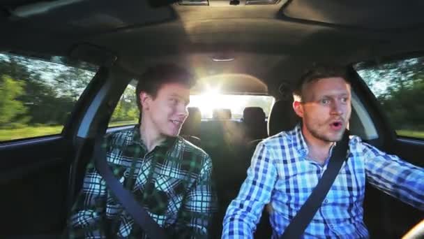 Grappige jongens rijden in auto, lachen, reizen in een zonnige dag — Stockvideo