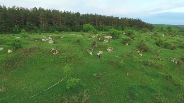 Luchtfoto van jonge jongen gaat met speelgoed vliegtuig op de groene bergen — Stockvideo