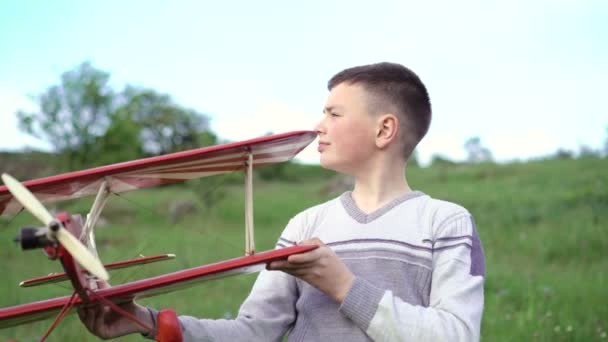 Knappe jongen speelt met speelgoed vliegtuig op de berg. 4k — Stockvideo