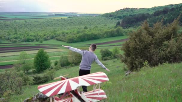 Garçon descendant la montagne, hélicoptère jouet devant. 4k — Video