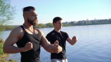 Wing Chun Eğitim egzersizleri güçlü erkekler arasında nehir yakınında. 4k
