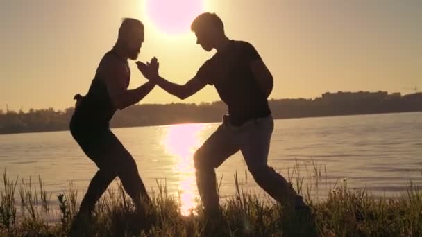 A luta Wing Chun no pôr-do-sol perfeito perto do rio. 4k — Vídeo de Stock