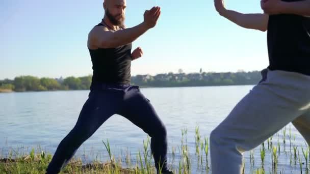 La lucha de Wing Chun cerca del río entre hombres fuertes. 4k — Vídeo de stock