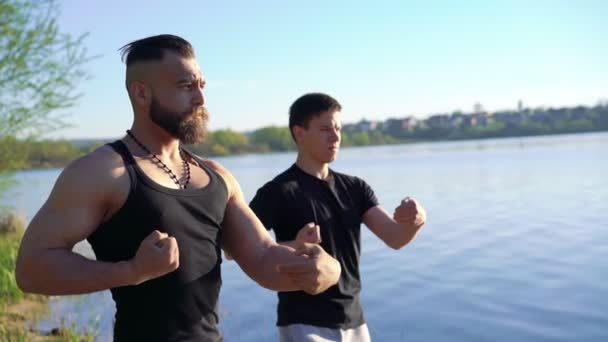 Oefeningen van Wing Chun nabij de rivier tussen de sterke mannen. 4k — Stockvideo