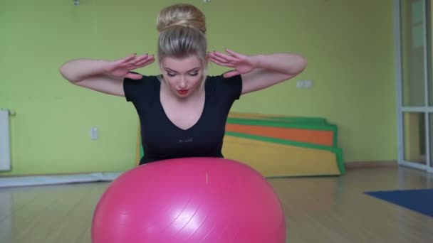 Instructor doing deflection back exercises with fitball behind a camera 4k — Stock Video