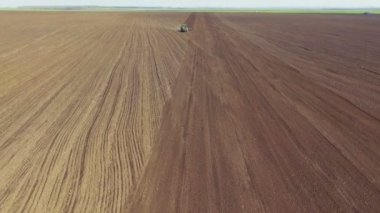 Toprak sahada güneşli bahar günü çiftçilik traktörün havadan görünümü