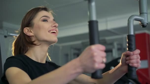 A lány az edzőteremben egy szimulátor — Stock videók