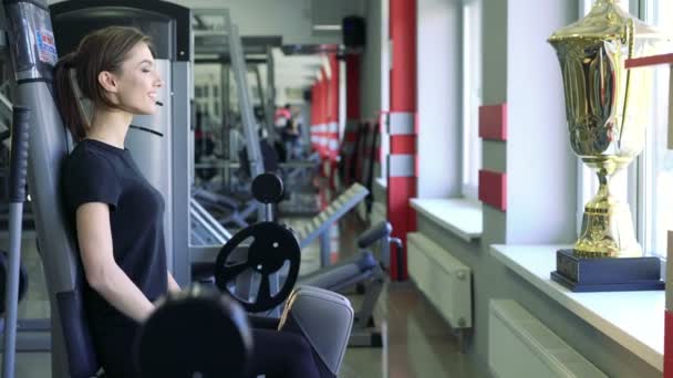 Chica en el gimnasio haciendo ejercicio piernas — Vídeos de Stock