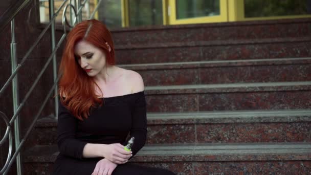 Страстная женщина, курящая электронную сигарету, сидит на лестнице 4k — стоковое видео